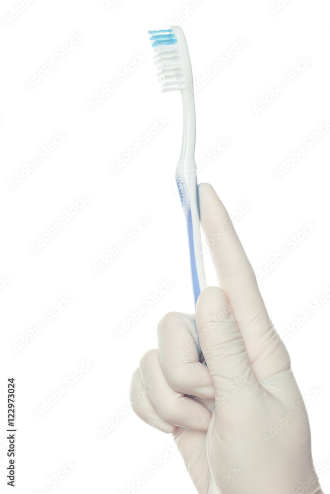 Gloved doctor's hand holding a toothbrush Gloved doctor's hand holding a toothbrush