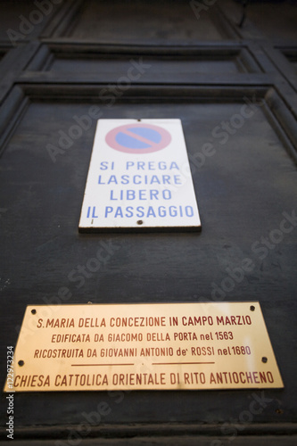 Traffic and information signs on the door of Santa Maria della Concezione in Campo Marzio church, Rome photo