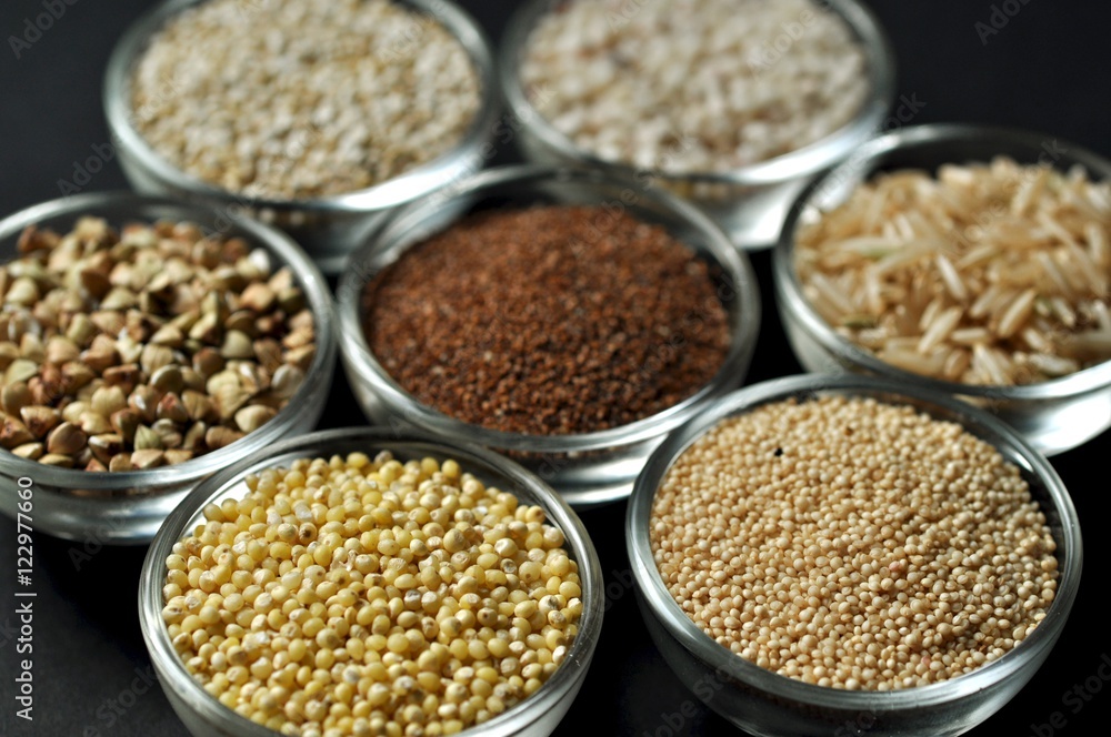 Gluten-free grains in glass bowls on black background close-up Gluten-free grains in glass bowls on black background close-up