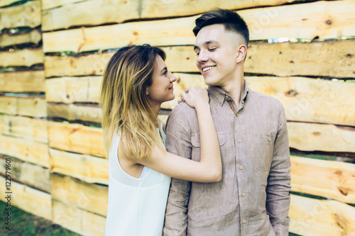 couple posing on a background of the wooden wall © teksomolika