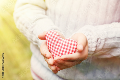 Foto Child hand holding red heart