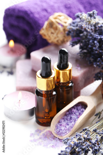 Lavender oil with soap and flowers on white background