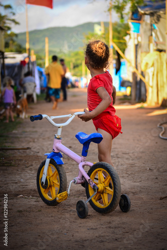 Little girl with bicicle in occupation camp photo
