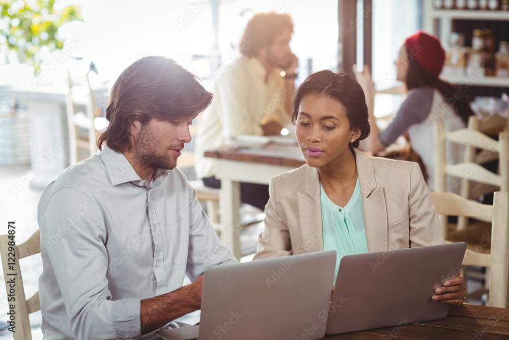Man and woman using laptop during meeting Man and woman using laptop during meeting