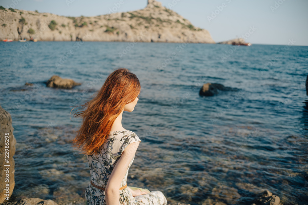 woman on the beach, sitting on a rock Woman, long hair in dress woman on the beach, sitting on a rock Woman, long hair in dress