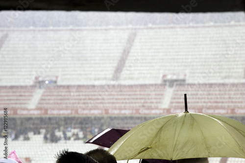 Spectators taking shelter from a heavy rain inside Sanchez Pizjuan stadium, Seville, Spain photo
