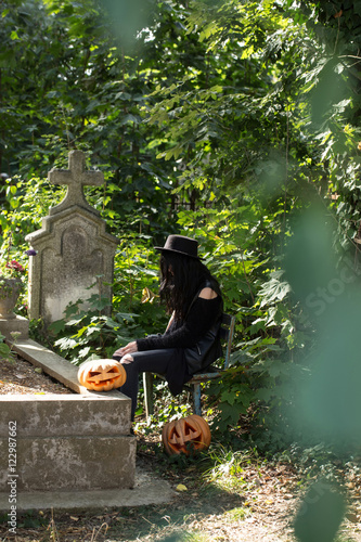 halloween woman with pumpkin on tomb