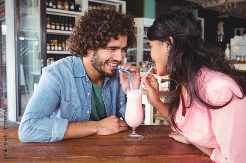 Slika na platnu Happy couple drinking milkshake