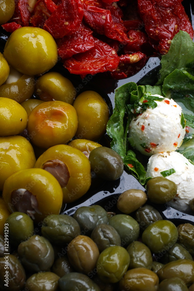 Selection of antipasta choices on a catering dish. Mozzarella cheese pepper and olives for appetizer. Selection of antipasta choices on a catering dish. Mozzarella cheese pepper and olives for appetizer.
