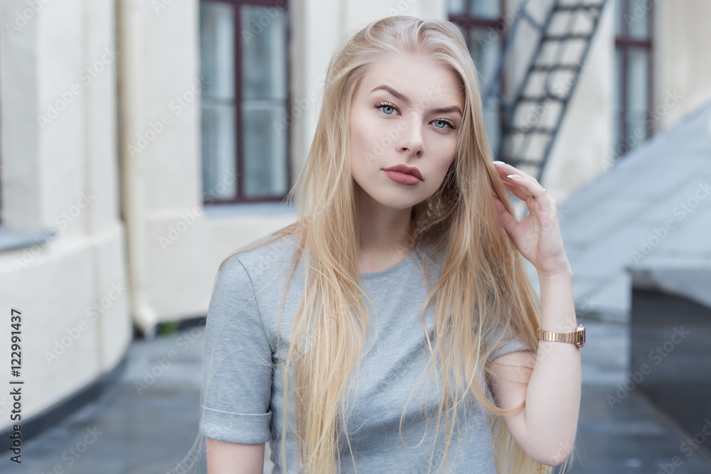 Fototapeta premium beautiful sexy blonde girl with long hair and full lips walk into town