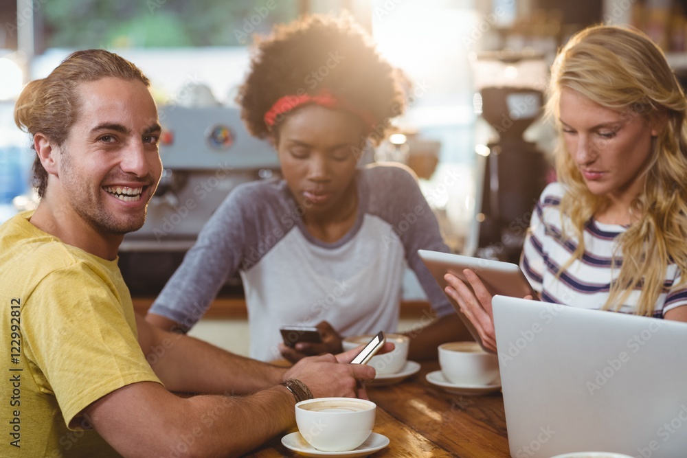 Group of friends using mobile phone and laptop