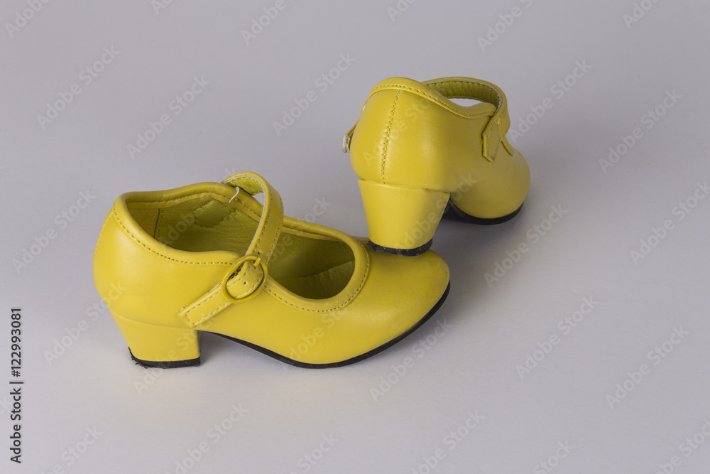 En la cabeza de danza soporte Zapatos amarillos de tacón de niña. foto de Stock | Adobe Stock