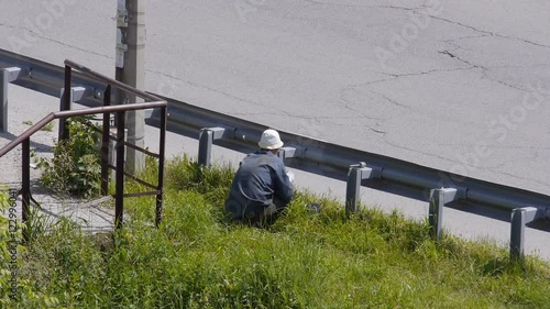 Wallpaper Mural Worker is painting fences along the roadside. He squats. Torontodigital.ca