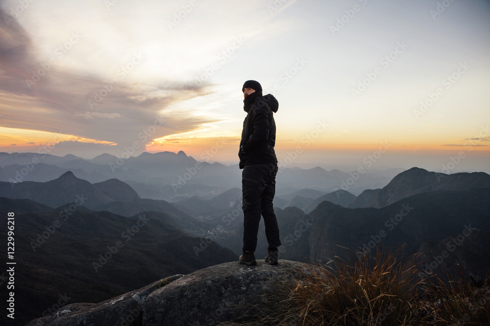 Man looking away while standing on mountain during sunset Man looking away while standing on mountain during sunset