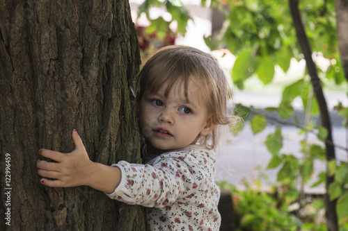 Little girl hugging tree / Little girl is typed energy from of the tree