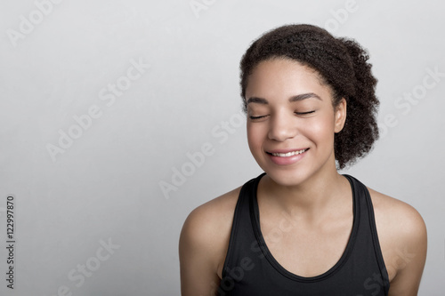 Smiling woman in sportswear with her eyes closed
