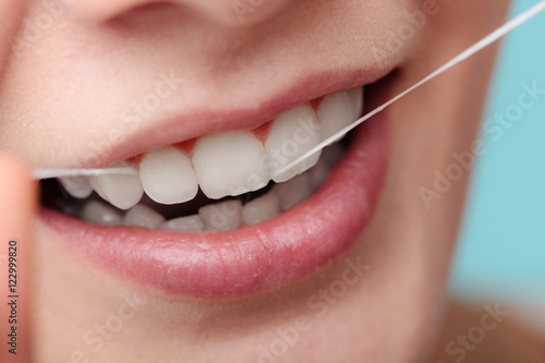 Woman smiling with dental floss.