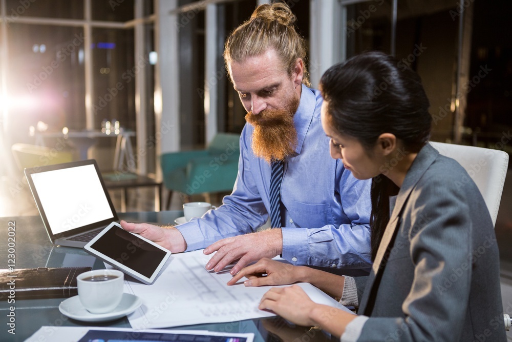 Fototapeta premium Businesswoman and colleague discussing over blueprint