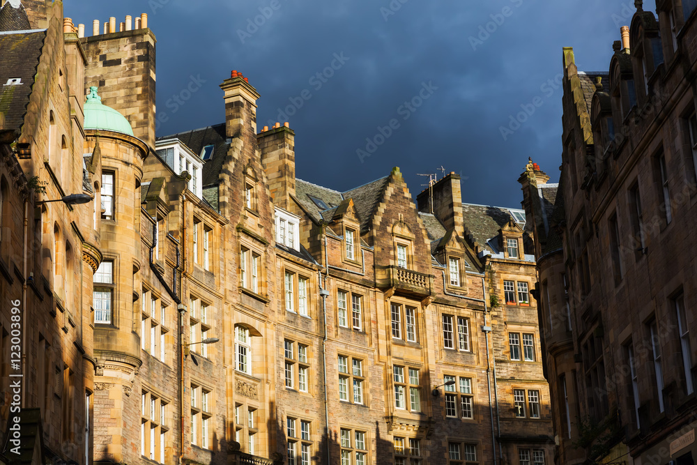 historic buildings in the Cockburn Street in the old town of Edinburgh, Scotland, with dramatic clouded sky