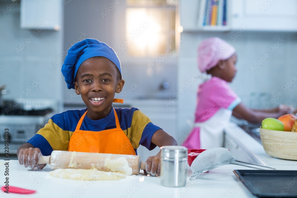 Boy preparing cake with sister in background Boy preparing cake with sister in background