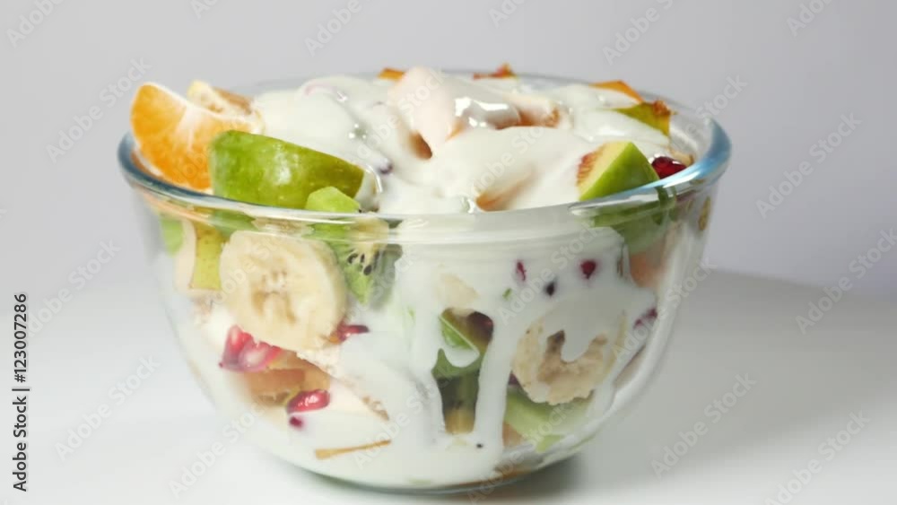 A fruit salad with mandarin, oranges, kiwi, pomegranate seeds, figs, banana and peaches A fruit salad with mandarin, oranges, kiwi, pomegranate seeds, figs, banana and peaches