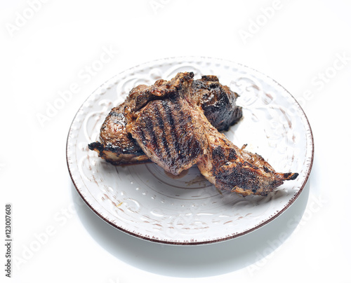 Grilled lamb steak on a plate on a white background