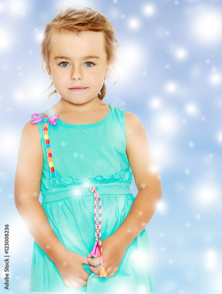 Beautiful little tanned girl in a blue dress. Beautiful little tanned girl in a blue dress.