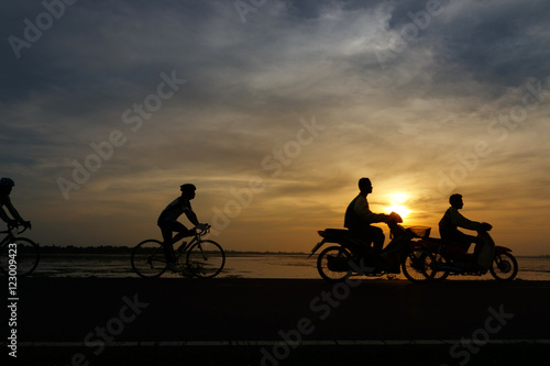 Silhouette ride bicycle at sunset. With effect subject movement