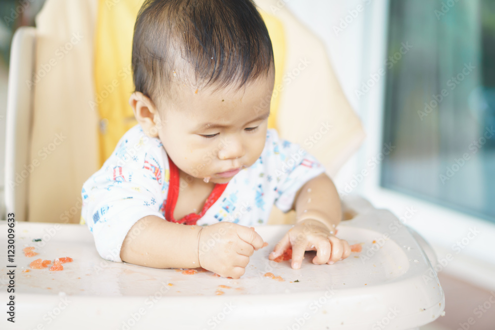 Asian baby eating food by himself Asian baby eating food by himself