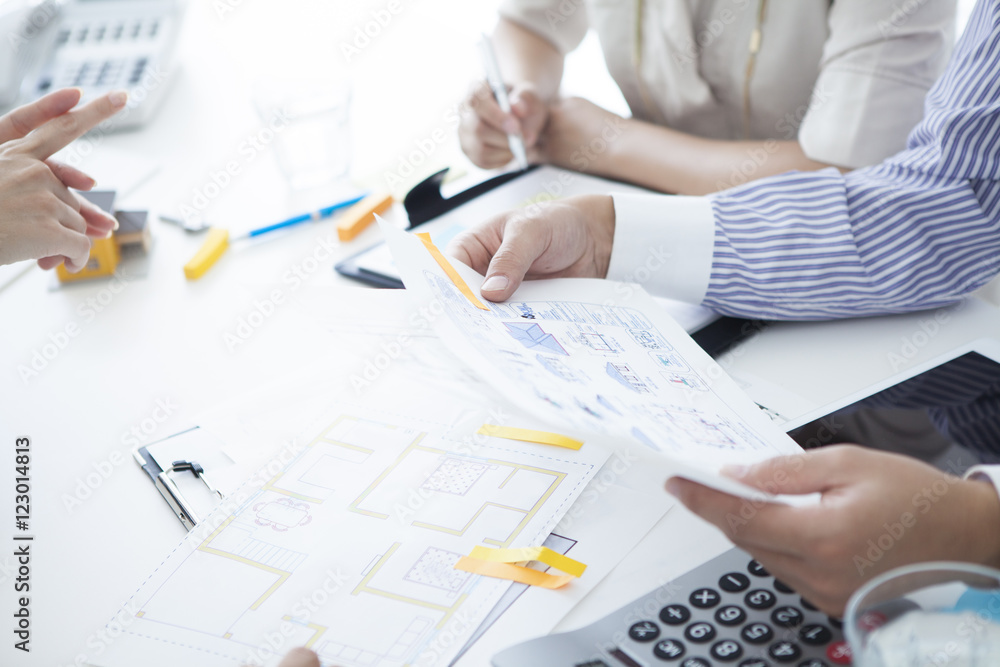 Businessmen have a meeting while looking at the blueprint Businessmen have a meeting while looking at the blueprint