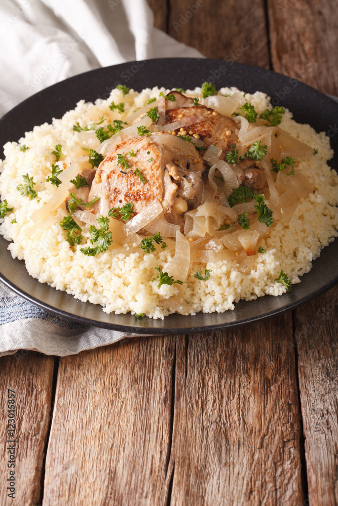 Poulet Yassa stewed with onions and garnished with couscous close up. vertical
Poulet Yassa stewed with onions and garnished with couscous close up. vertical