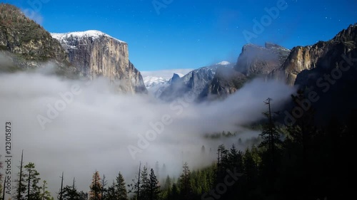Time lapse with tilt up motion of iconic Tunnel View at foggy fullmoon night in Yosemite National Park, California photo