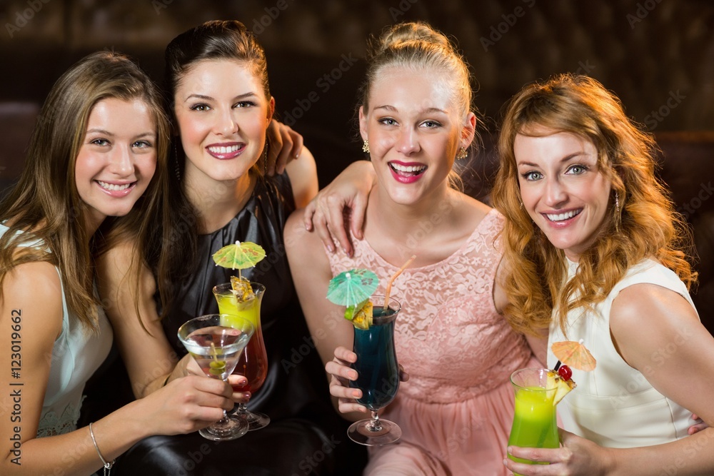 Female friends holding glasses of cocktail in bar Female friends holding glasses of cocktail in bar