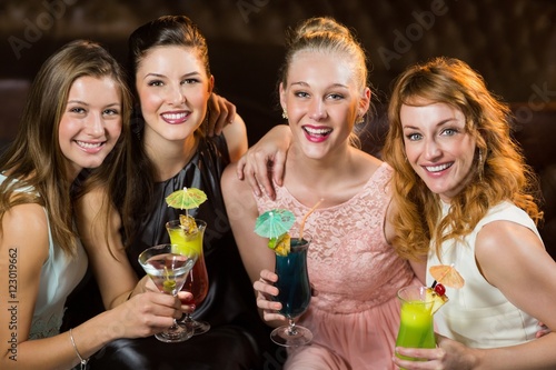 Female friends holding glasses of cocktail in bar