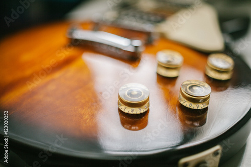 Part of Electrical guitar body close up.Focused detailing button in film and grain tone