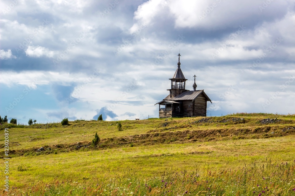 Traditional wooden chapel on hill. Summer landscape with cloudy sky. Kizhi Island, Russia