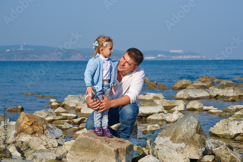 Happy father and his little daughter at beach