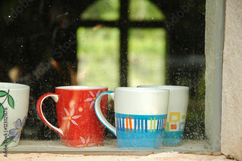 Warm coffee cups inside a window of a cozy house