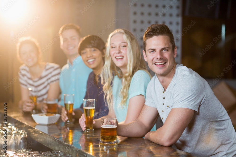 Group of friends having glass of beer at bar counter Group of friends having glass of beer at bar counter