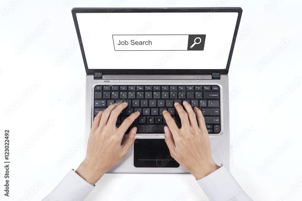 Hand typing job search on the laptop Hand typing job search on the laptop