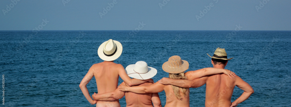Family in hats standing on the beach