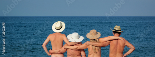Family in hats standing on the beach photo