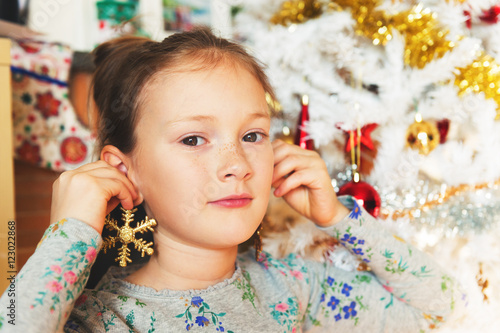 Close up portrait of a cute little girl playing with Christmas toys
