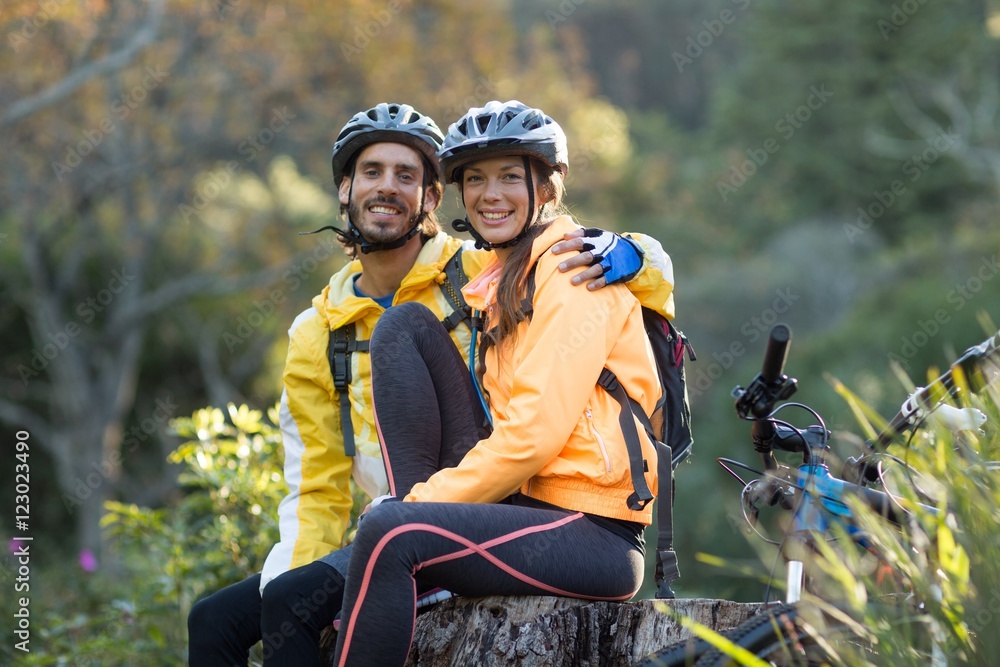 Naklejka premium Biker couple sitting on a tree stump
