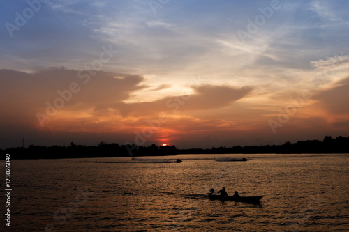 Silhouette of long tail boat on Tapee river Suratthani Thailand in evening time