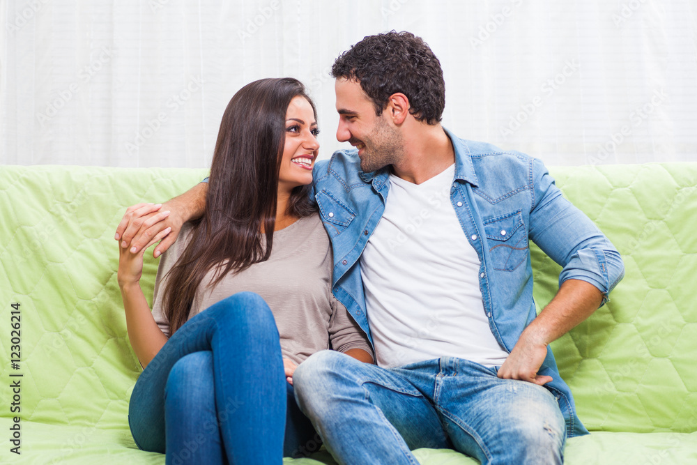 Happy couple sitting on sofa at their home. Happy couple sitting on sofa at their home.