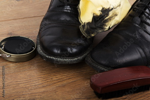 Shoes and cleaning equipment on a wooden floor