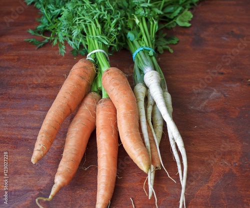 young carrots and parsley on a wooden background