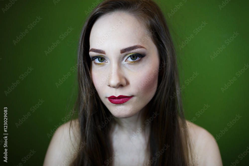Fototapeta premium Portrait of a beautiful young girl on a dark green background