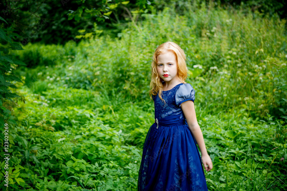 Portrait of beautiful little girl in the blue dress on the nature Portrait of beautiful little girl in the blue dress on the nature